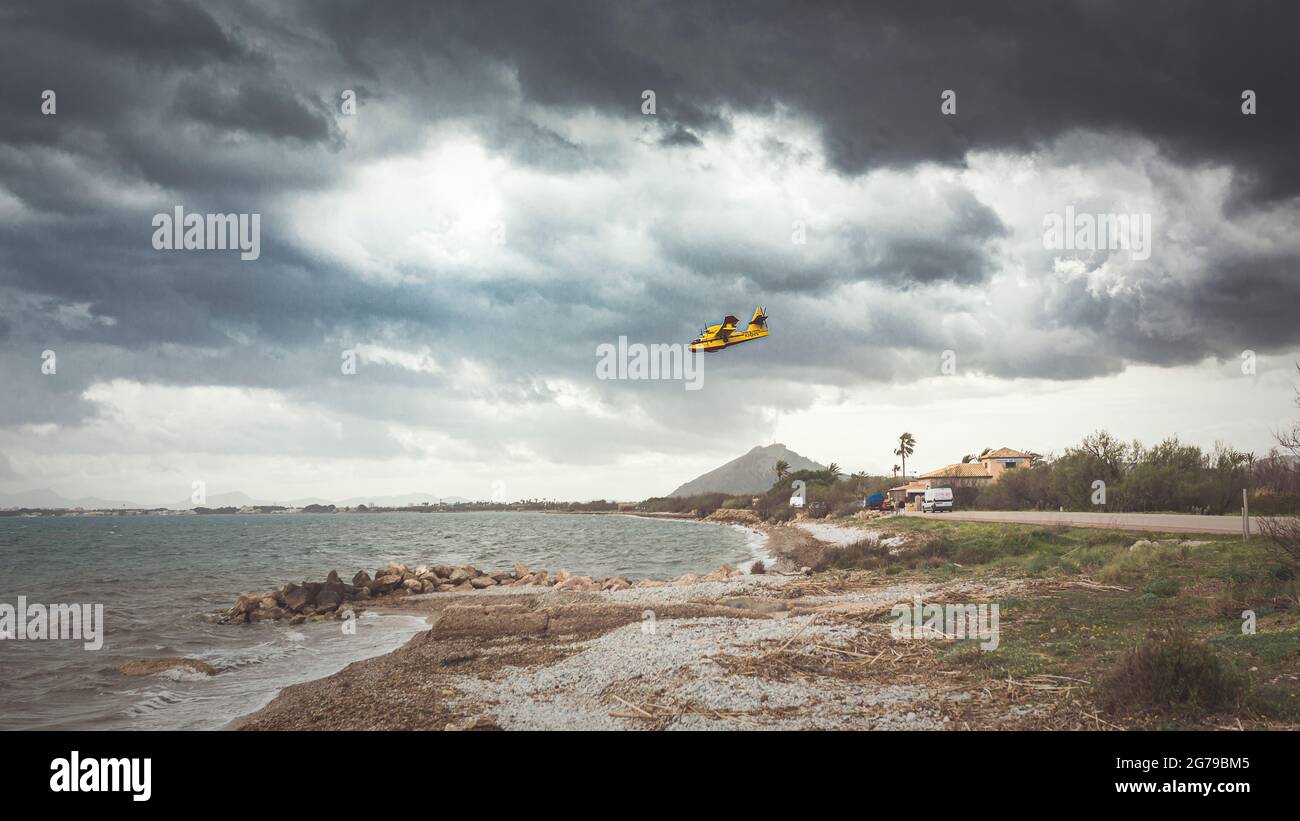 Fire-fighting aircraft over the sea with a thunderstorm atmosphere Stock Photo
