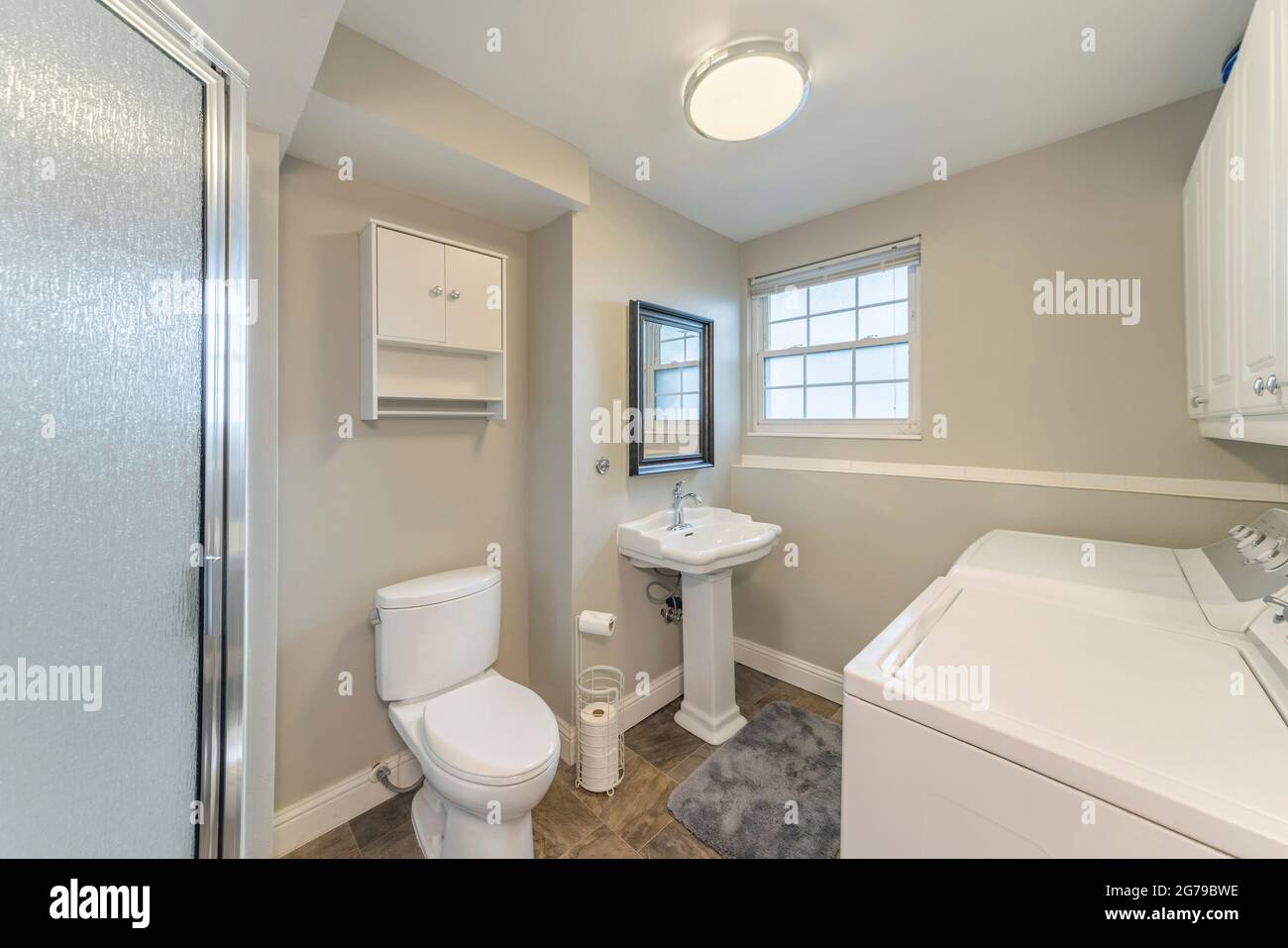 Bathroom and laundry room with shower stall and wall Stock