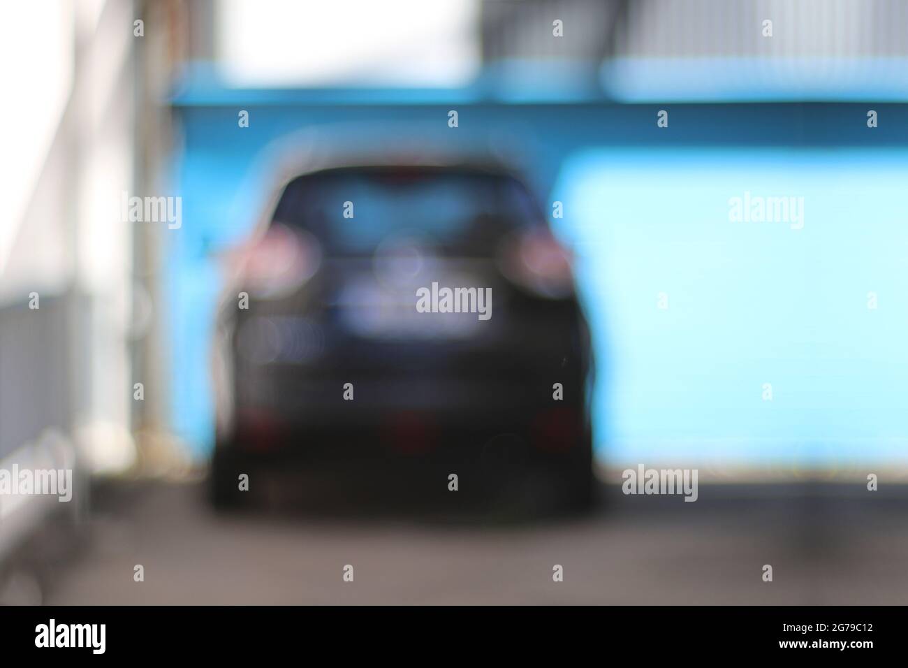 Parking lot with car against a blue background. Emotional motifs with blurring, background / graphics / composing / real photography without blurring filters Stock Photo