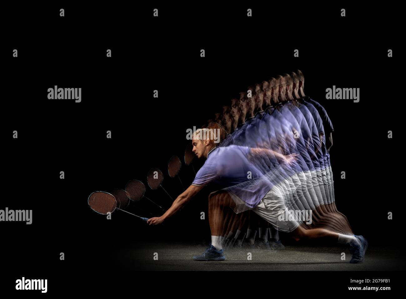 One young male badminton player, shuttler training isolated on dark ...