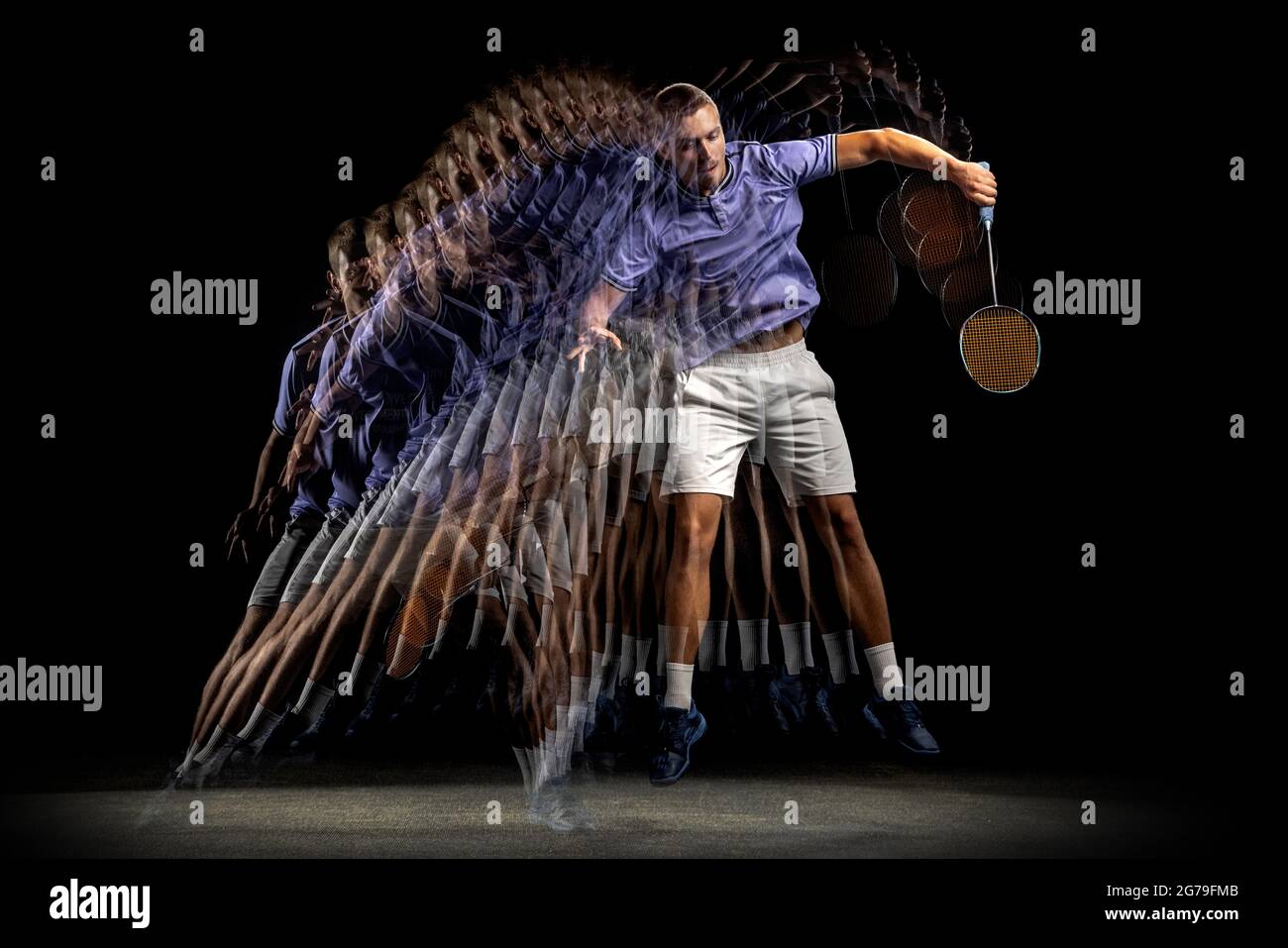 One young male badminton player, shuttler training isolated on dark ...