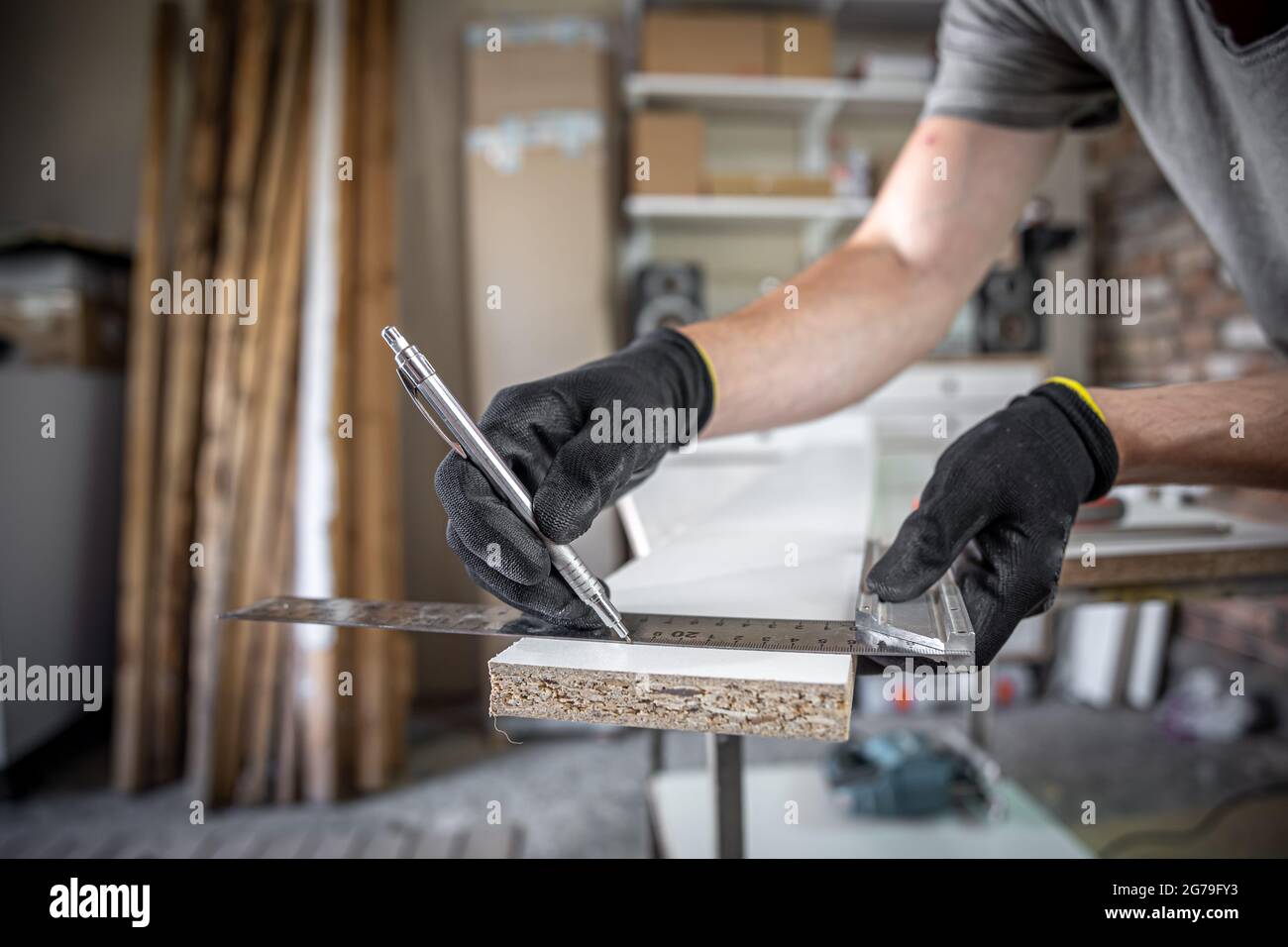 Carpenter Using Ruler Close up of carpenter holding ruler and pencil while making marks on ...