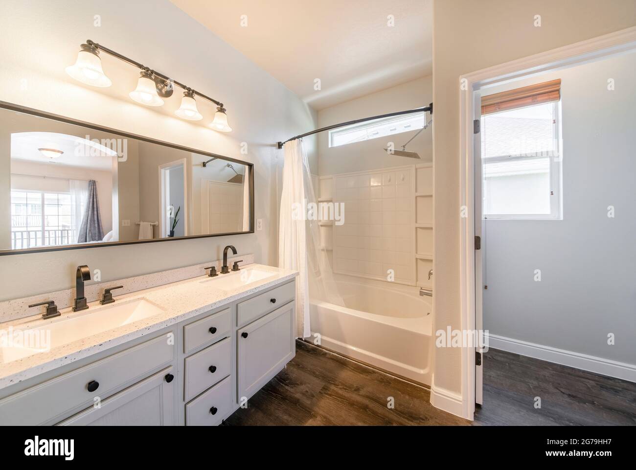 Open white masters bathroom with double vanity sink and bathtub shower