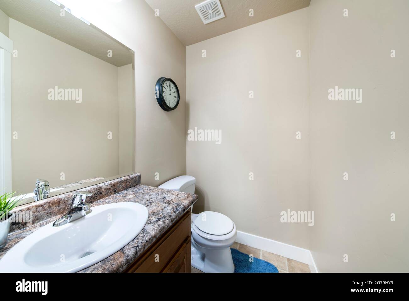 Bathroom interior with vanity sink with granite counter and wall clock Stock Photo