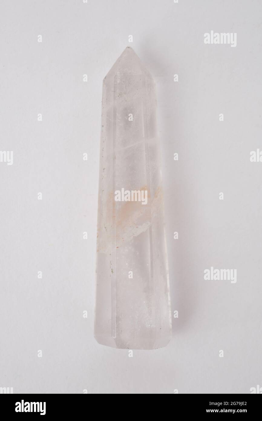 A clear Quartz point, gemstone used for healing photographed against a white background Stock Photo