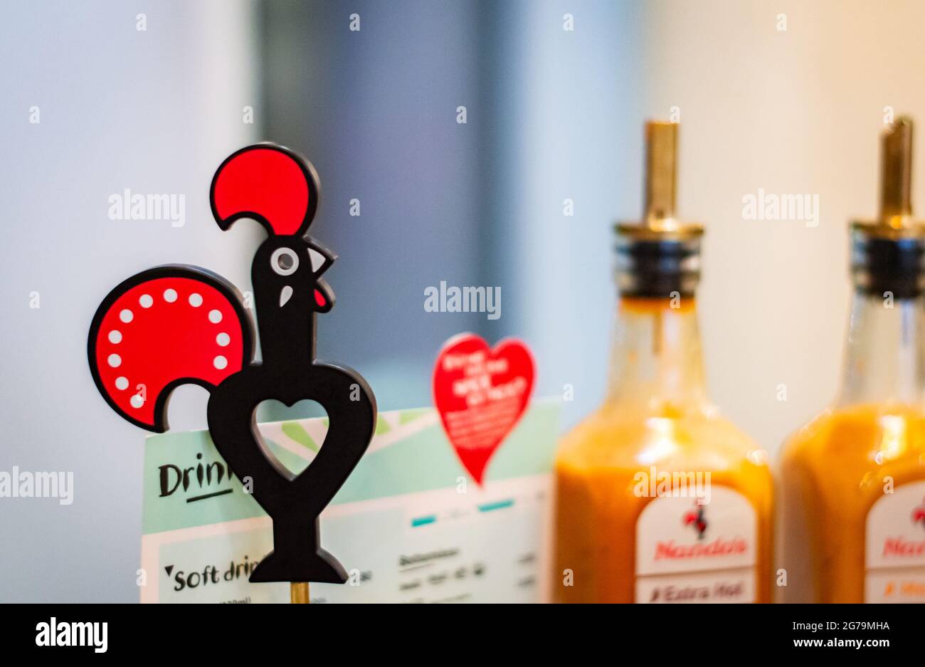 Bournemouth, UK. Nov. 6th, 2019. Restaurant Nando's logo, menu and peri peri sauce blurred at the background. Stock Photo