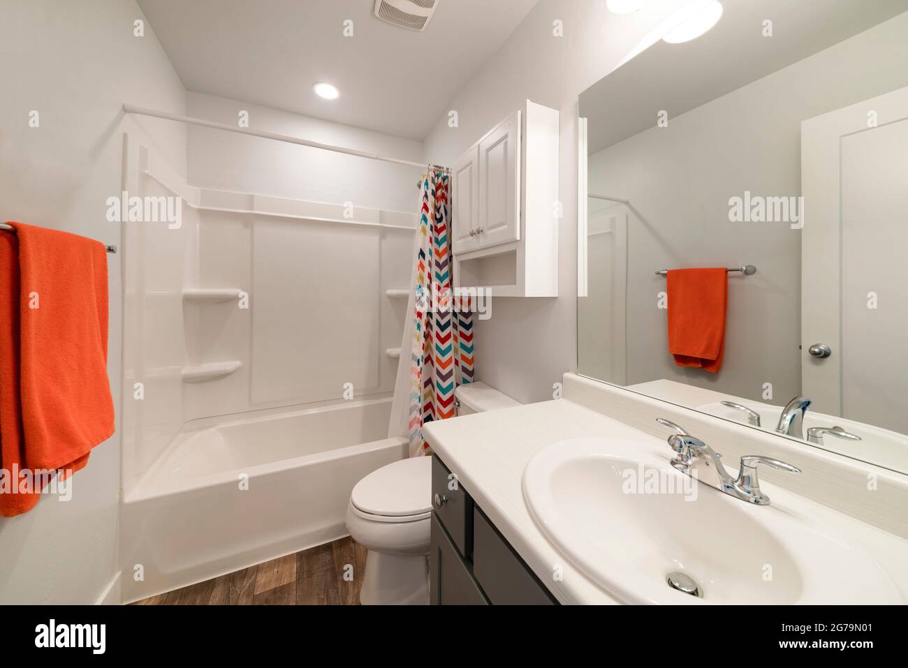White bathroom with wall and colorful shower curtain Stock