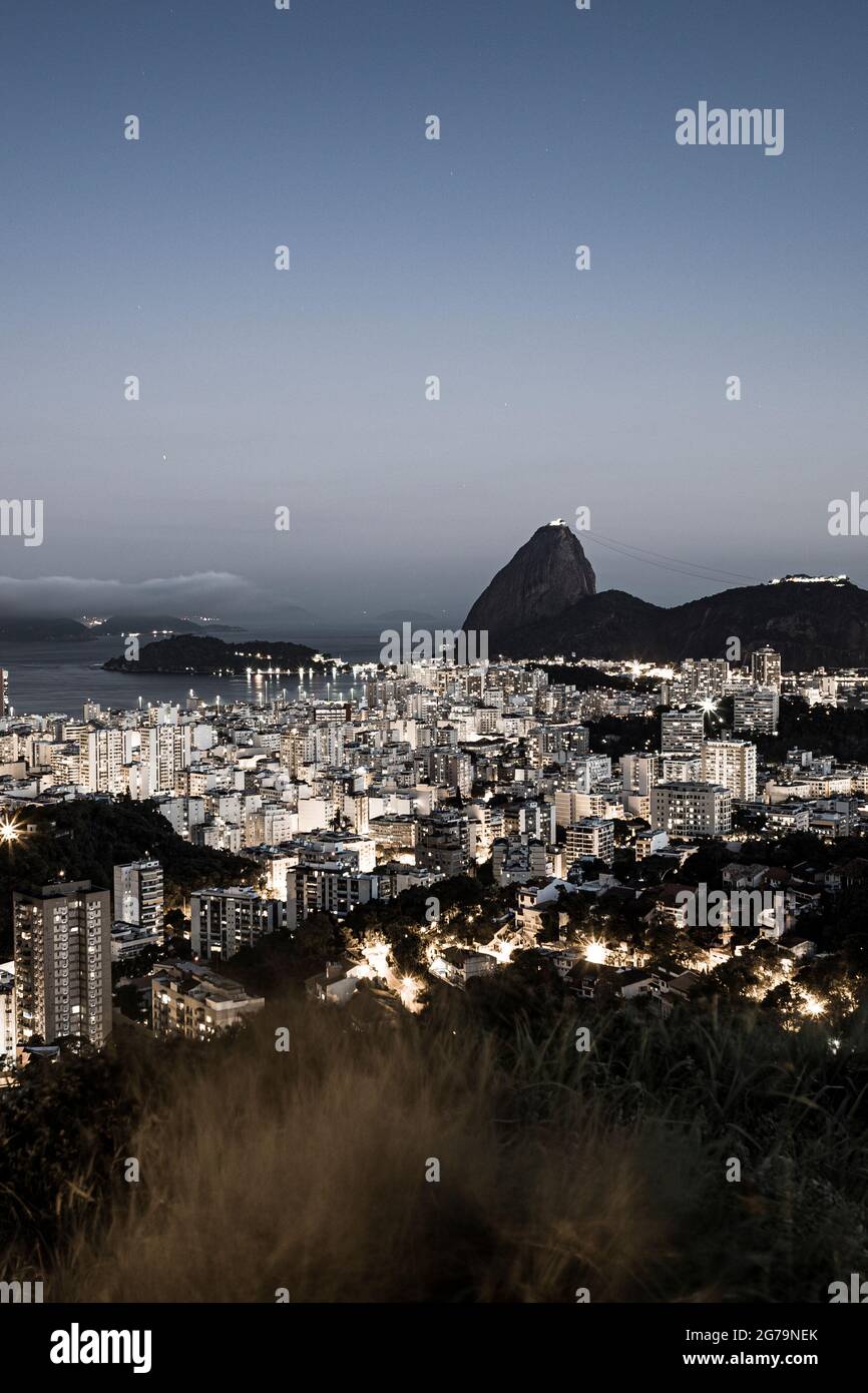Panoramic view at sunset of Sugarloaf Mountain (Morro pao de açúcar) and Bahia de Guanabara with the district Botafogo in Rio de Janeiro, Brazil Stock Photo
