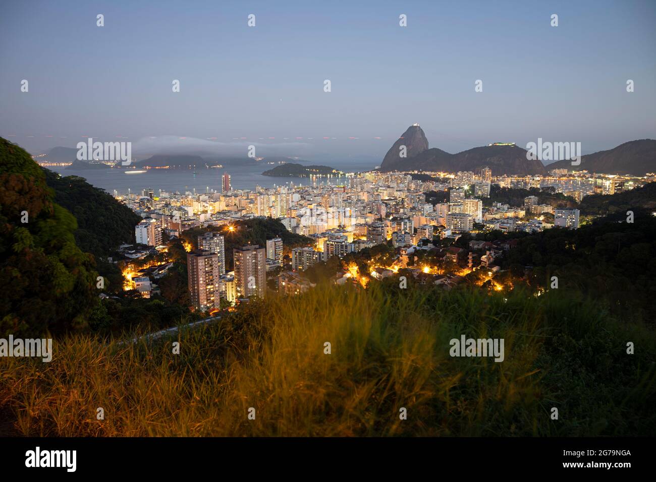 Panoramic view at sunset of Sugarloaf Mountain (Morro pao de açúcar) and Bahia de Guanabara with the district Botafogo in Rio de Janeiro, Brazil Stock Photo