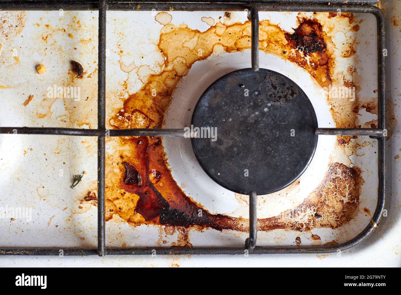 Dirty grease stove with food leftovers. Unclean gas kitchen cooktop