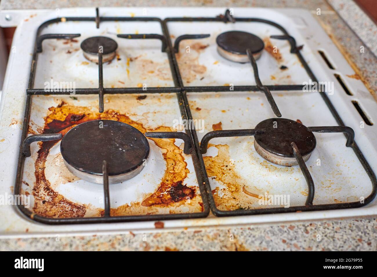 Dirty stove with food leftovers. Unclean gas kitchen cooktop with