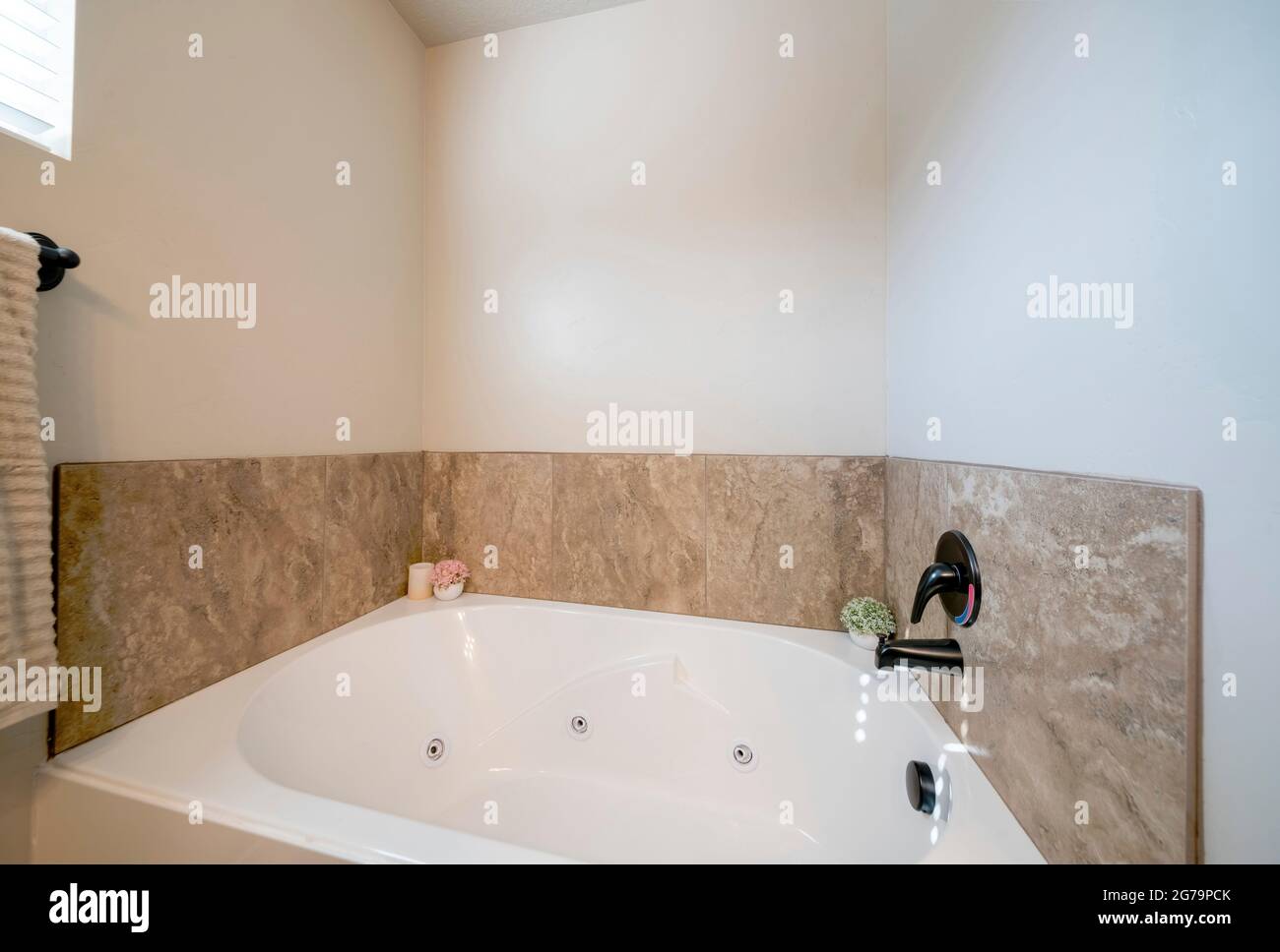 Drop in bathtub in a bathroom with decorative flower plants and candle