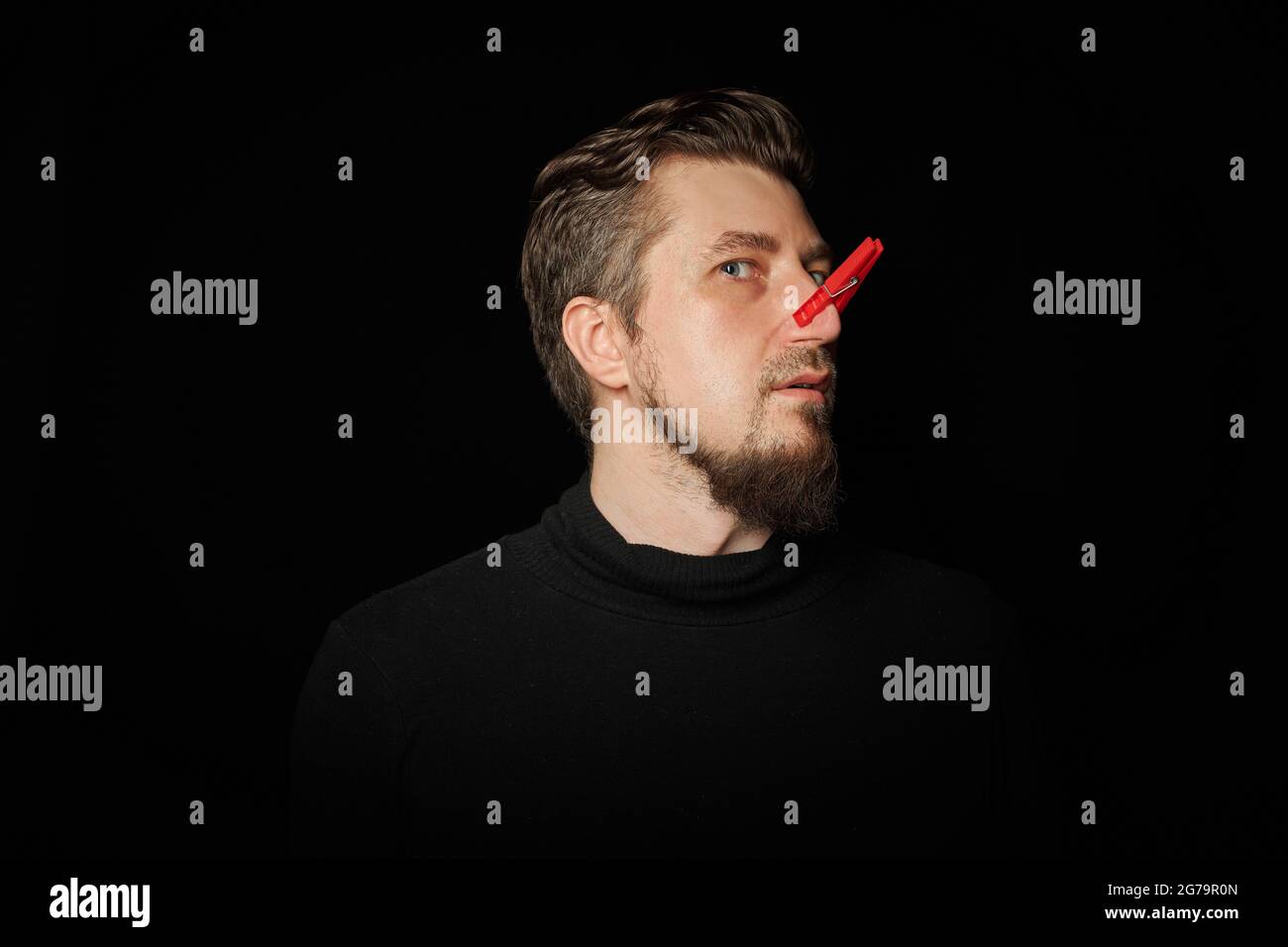 Bearded man with clothespin on nose. Bad stink, funny prankster, joke