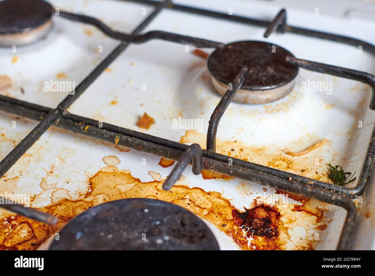 Dirty grease stove with food leftovers. Unclean gas kitchen cooktop
