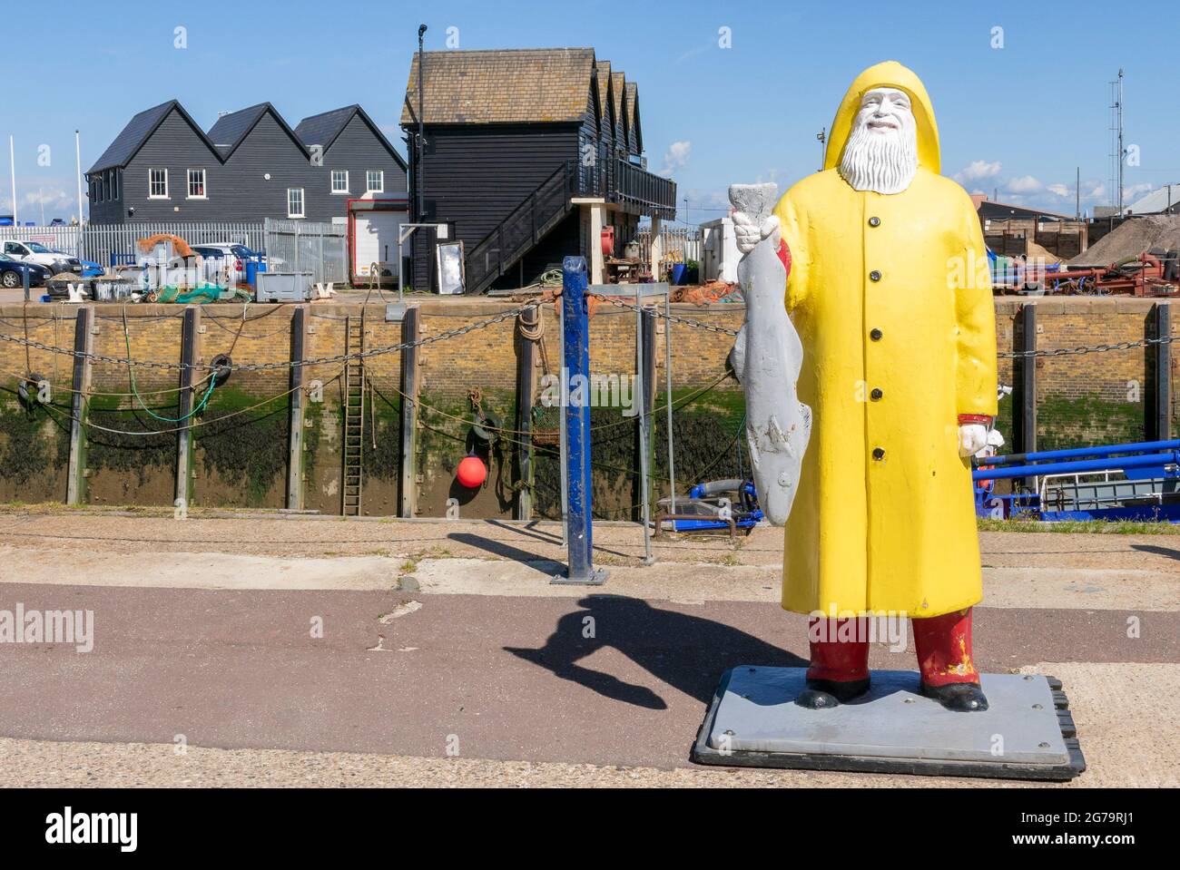 Whitstable Harbour Fisherman in yellow Oilskins carrying a fish or Trawlerman Model promoting the Fish Market at Whitstable Kent England UK GB Europe Stock Photo