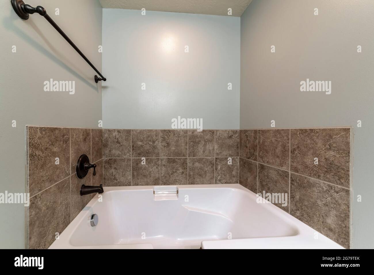 Bathroom interior with drop in tub with brown tile surround Stock Photo