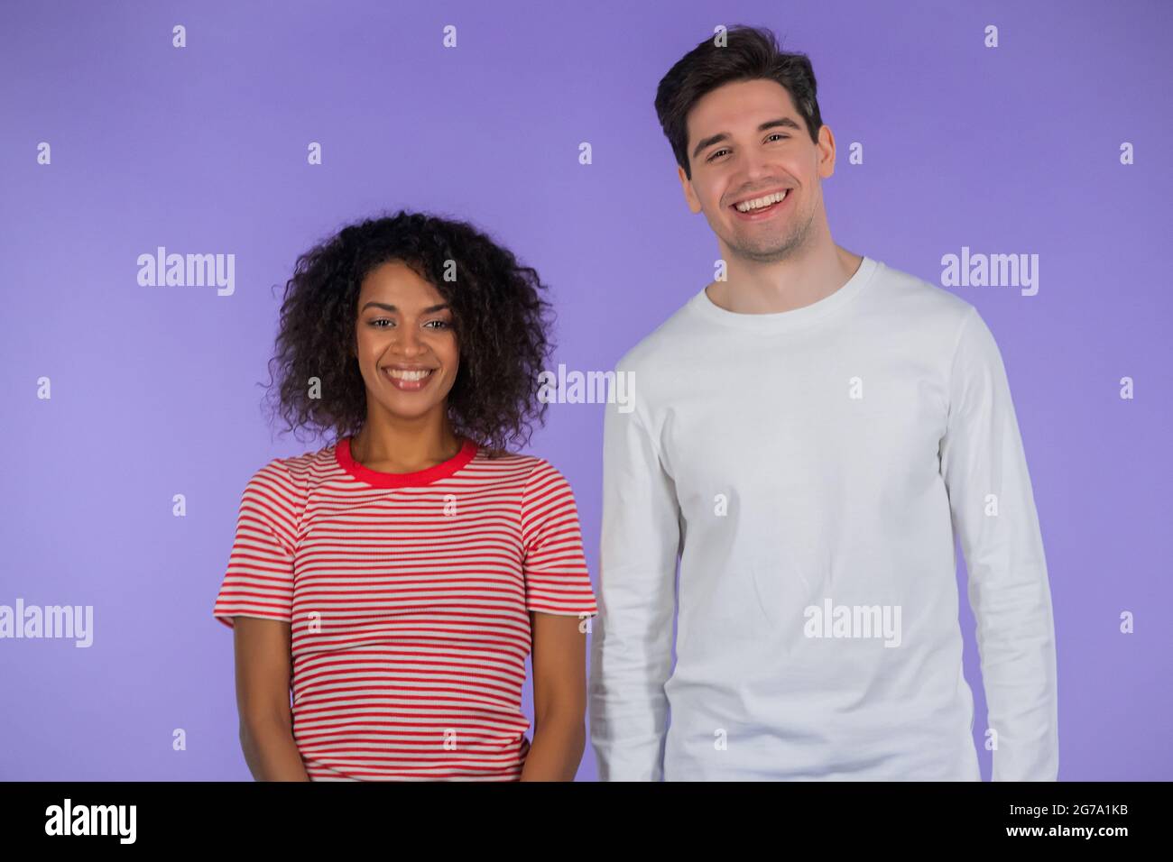 Portrait of young couple on purple studio background. African american woman and white man. Interracial race love concept Stock Photo