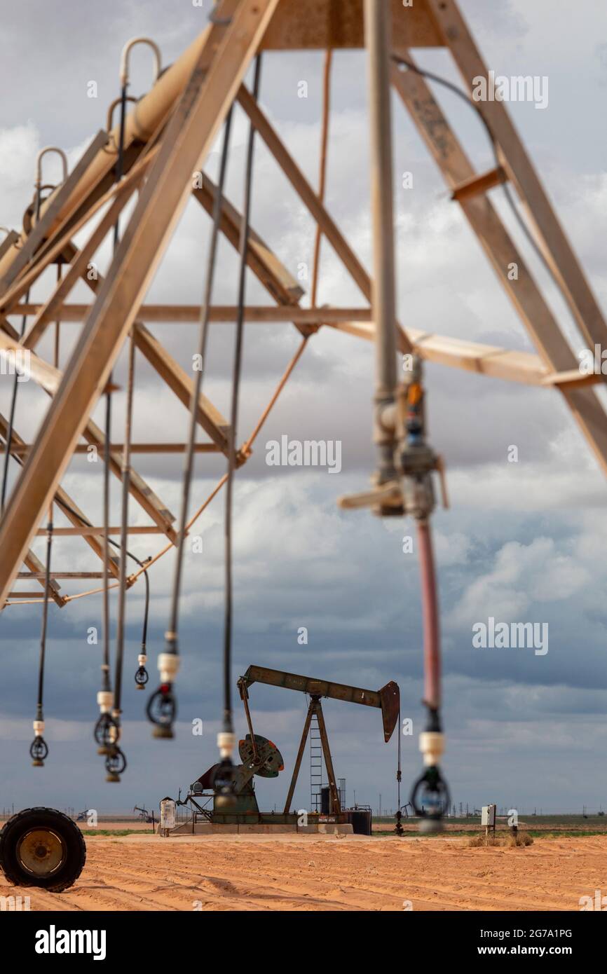 Plains, Texas - An oil well near irrigation equipment on farm land in the Permian Basin. Stock Photo