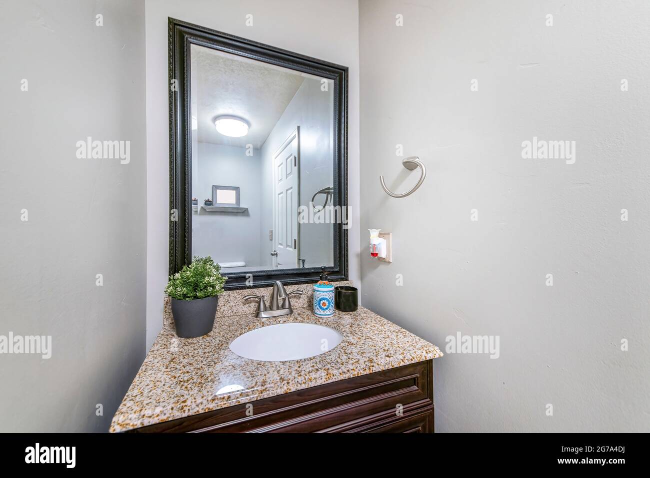 Single vanity sink with framed mirror and granite countertop Stock