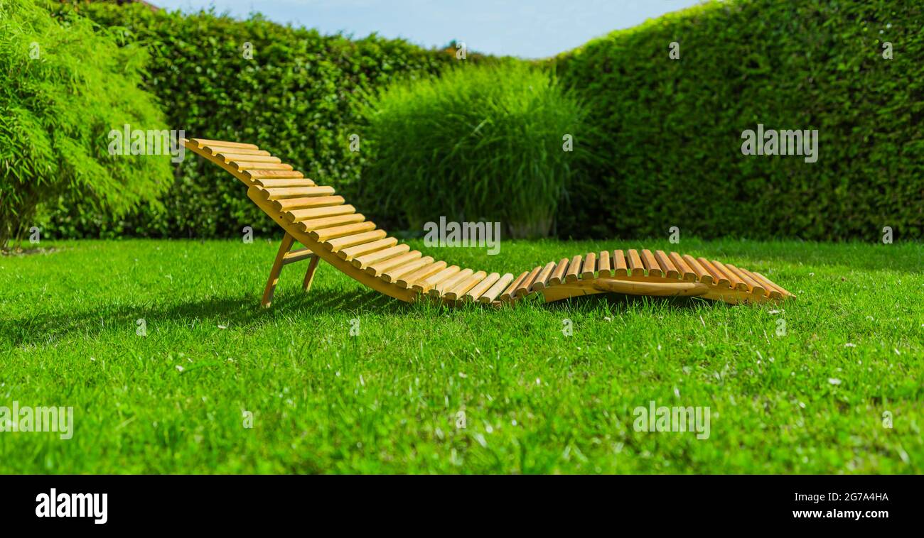 Wooden sun lounger in a garden Stock Photo