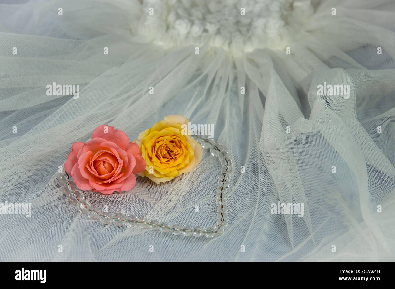 pink and yellow roses over white wedding dress Stock Photo - Alamy