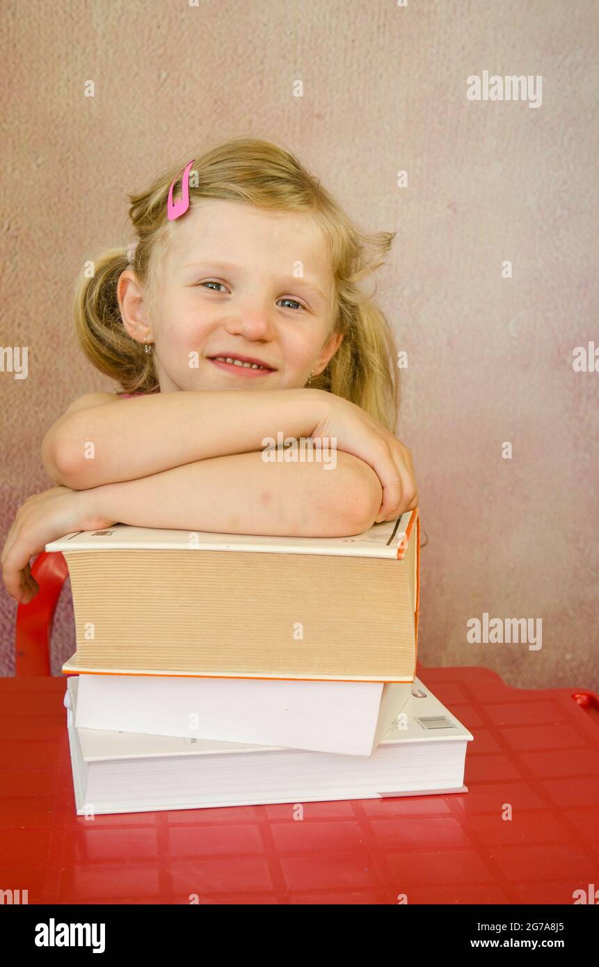 adorable girl with pile of books Stock Photo - Alamy