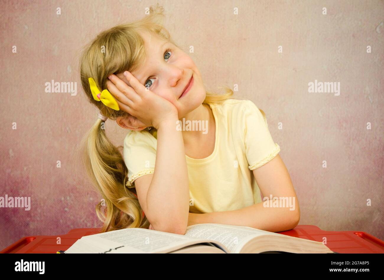 beautiful thoughtful blond girl with open book Stock Photo