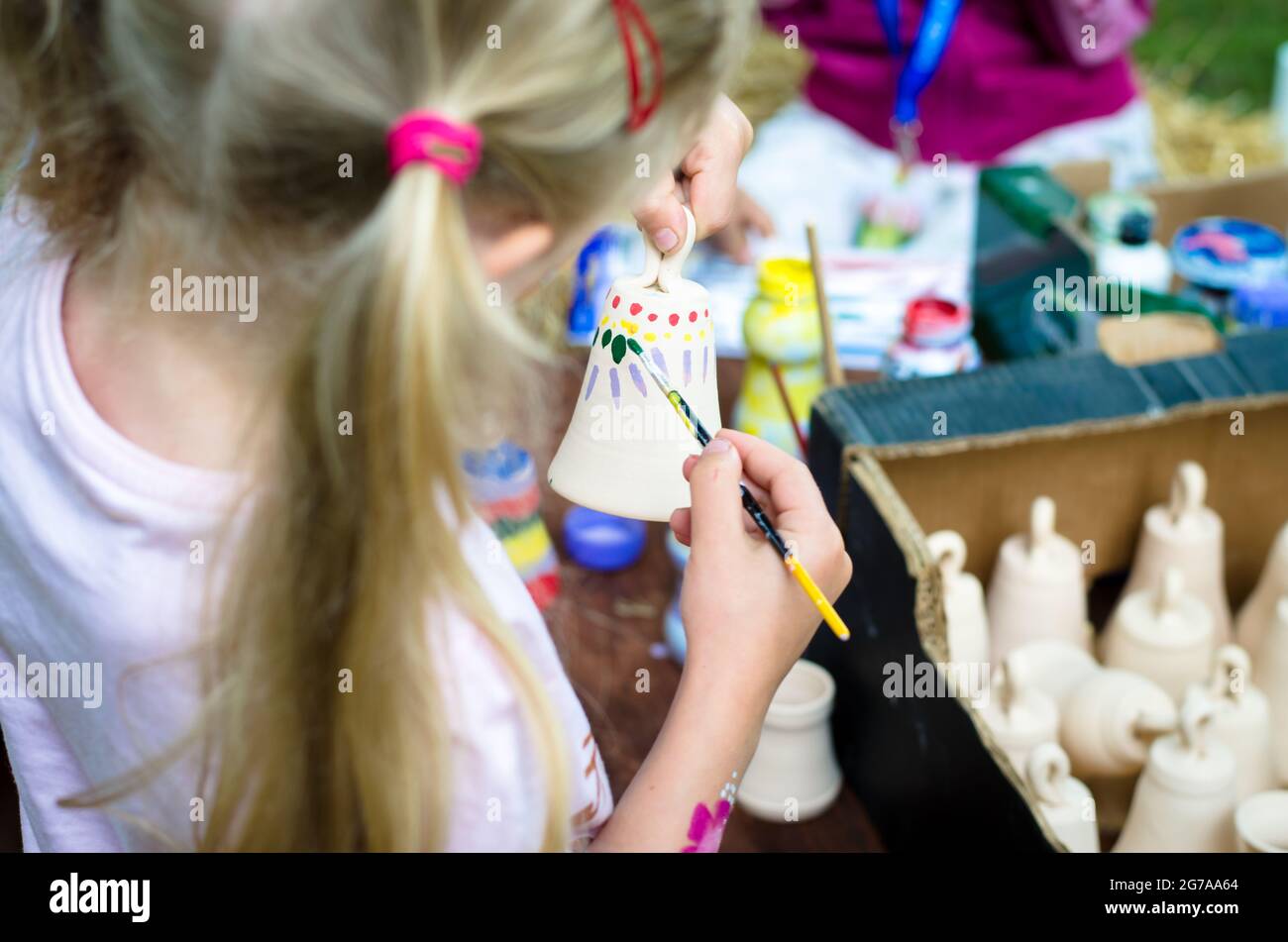 little child colouring an ceramics craft Stock Photo