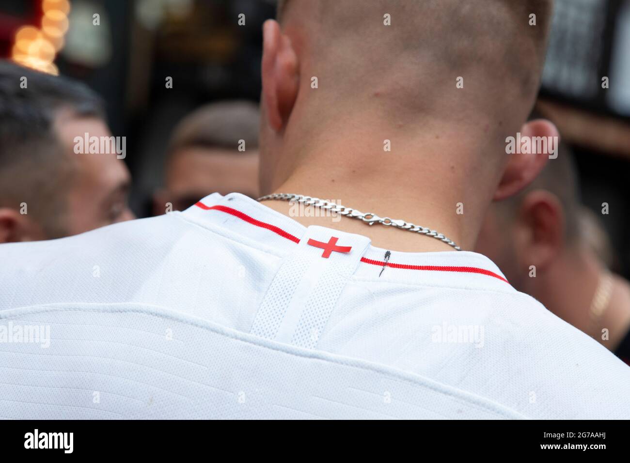 A St.George's Cross on the collar of a football shirt as England fans congregate on Leicester Square ahead of the Euro 2020 Final England vs. Italy. Stock Photo