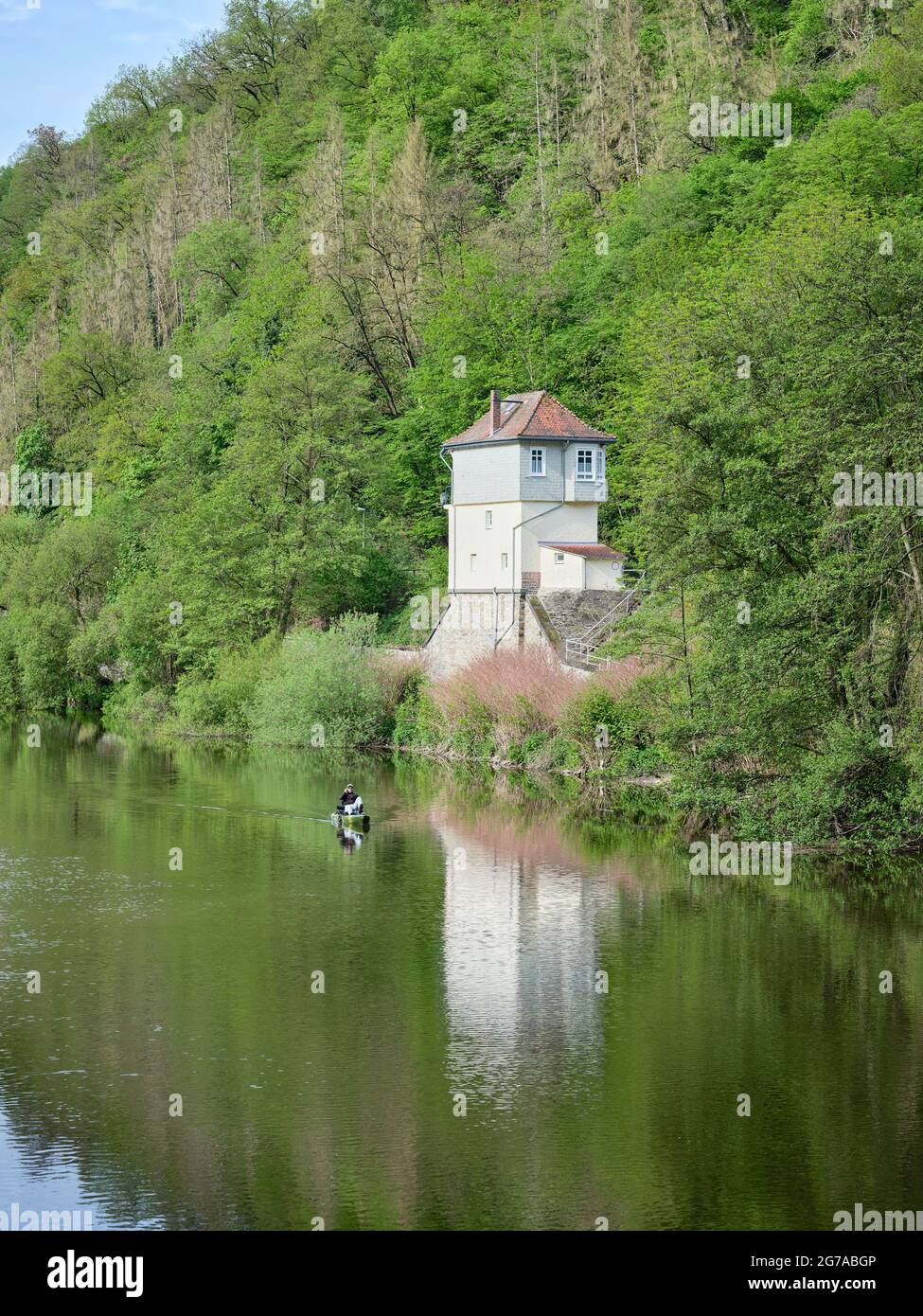 A pedal boat driver in Bad Ems on the Lahn and a train station on the bank, in Rhineland-Palatinate Stock Photo