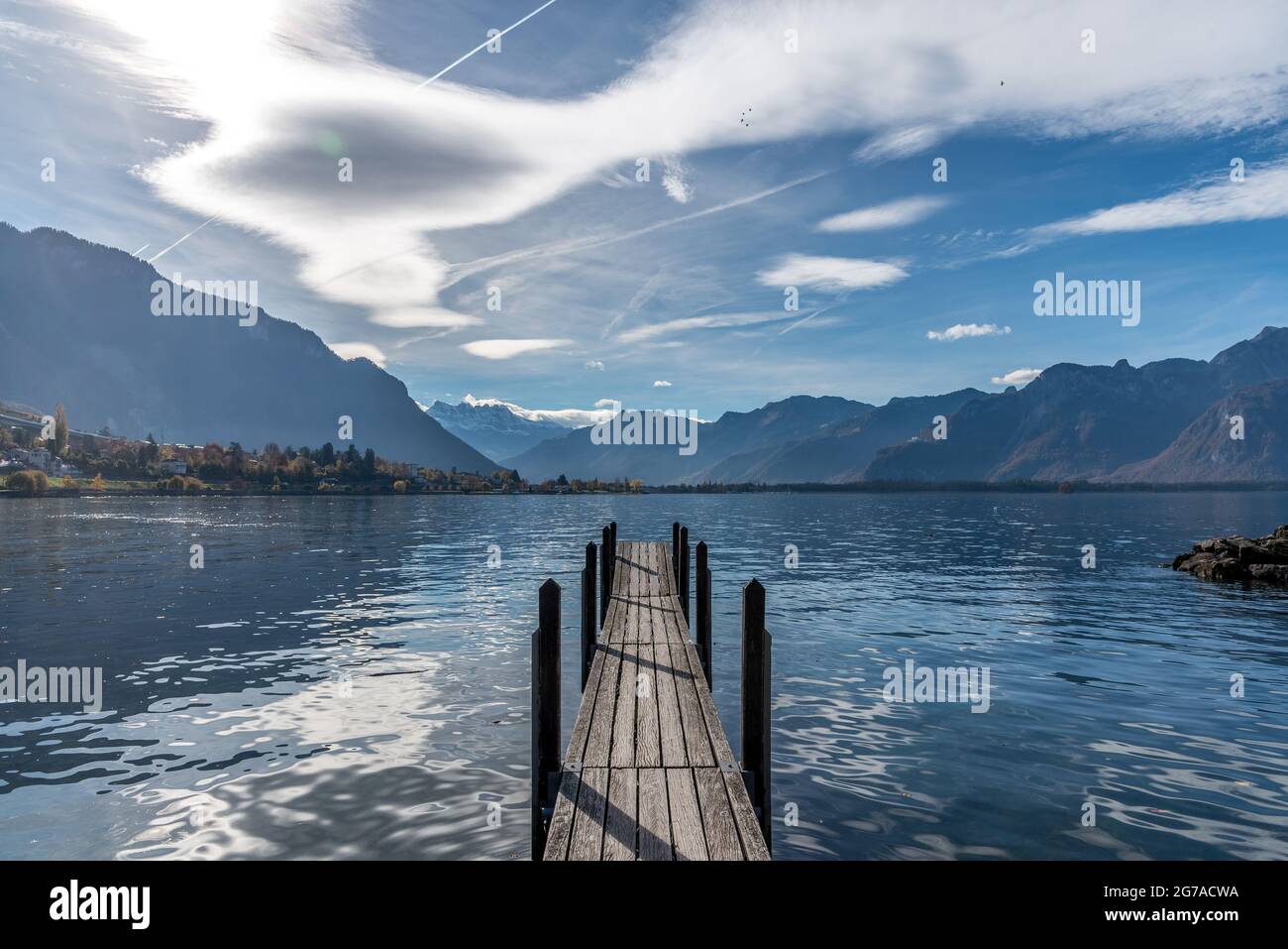 Beautiful landscape with mountains, lake and a small pier during cloudy day. Stock Photo