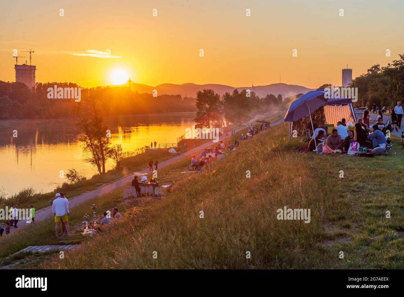 Vienna, sunset at river Neue Donau (New Danube), barbecue zone, people grill meat, view to North