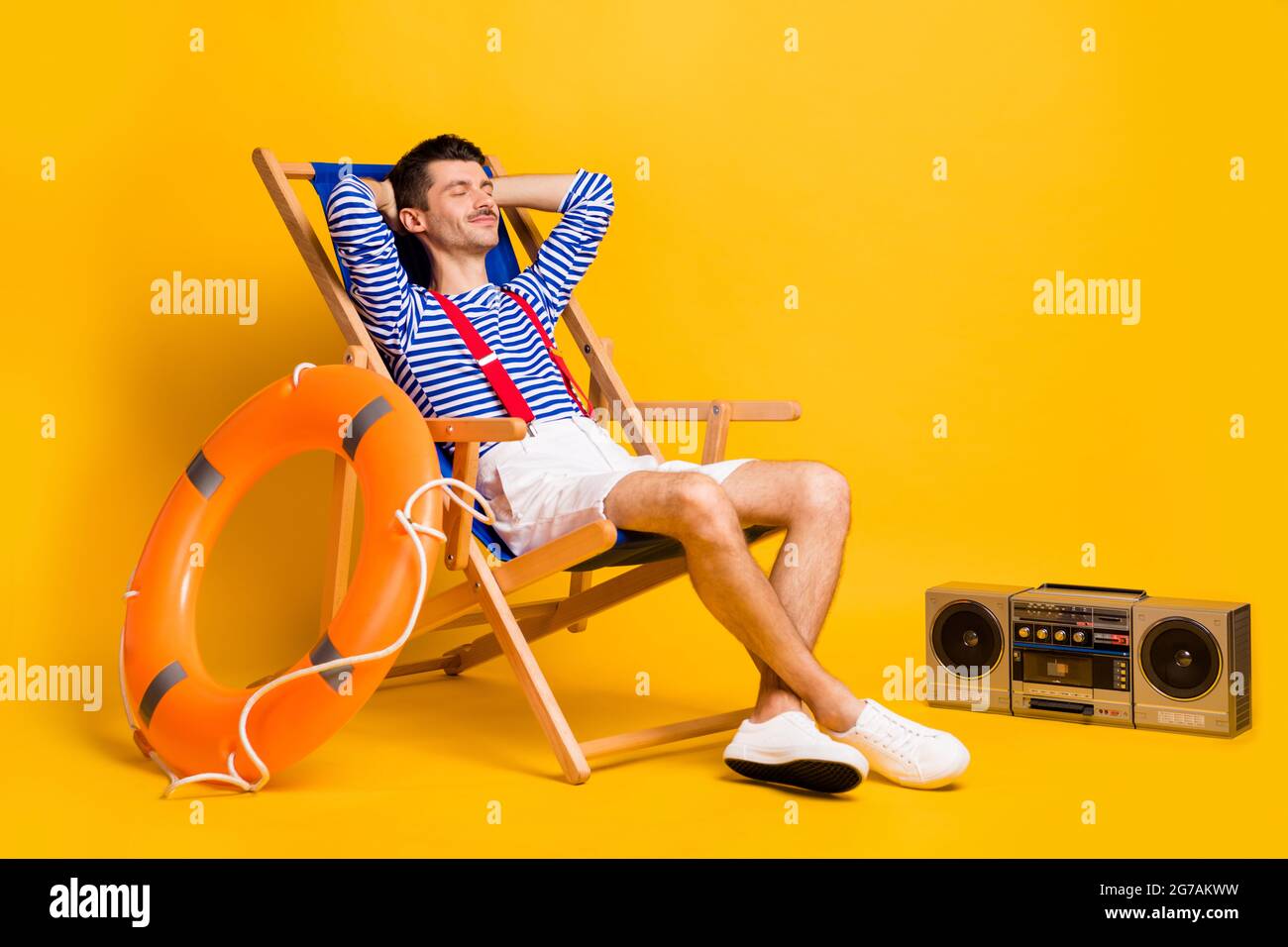 Full size photo of sleepy relaxed young man lie chair nap lifeguard isolated on yellow color background Stock Photo