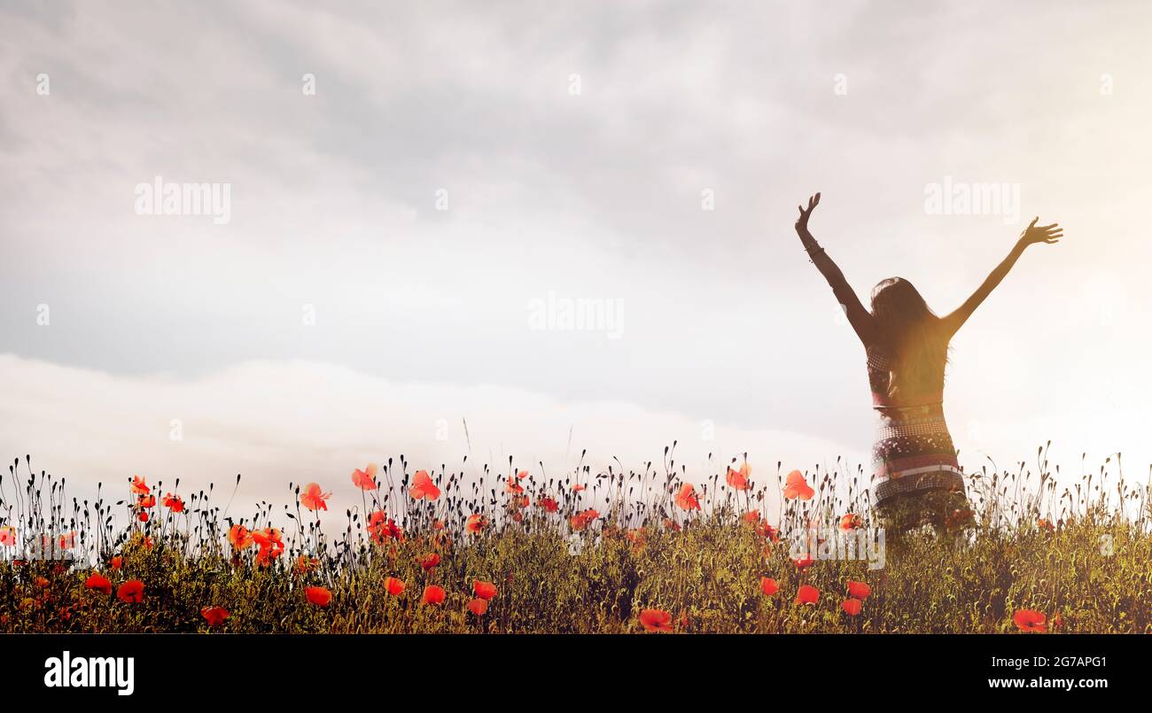 Cheerful woman in a poppy field Stock Photo