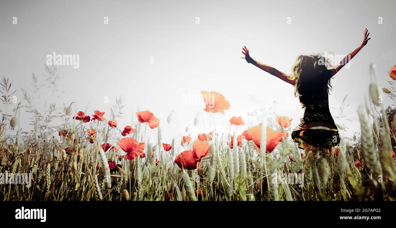Cheerful woman in a poppy field Stock Photo