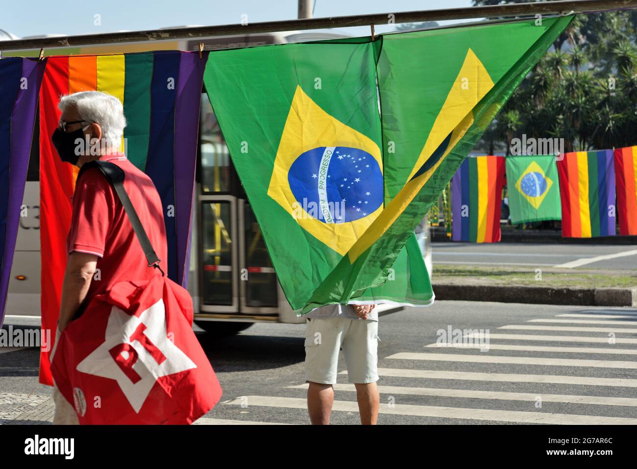 Rio de Janeiro – July 3, 2021:Street vendors sell Brazil's national flag and Workers Party and LGBT flags during a protest against President Bolsonaro Stock Photo