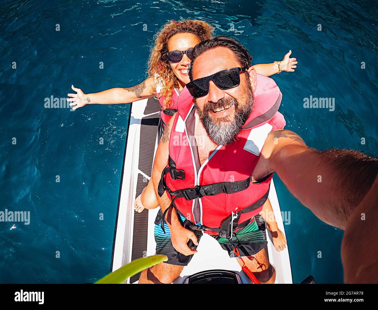 Top view selfie image of joyful young adult couple on a jet sky adventure lifestyle - happy couple people smile and have fun in summer holidays vacation together Stock Photo