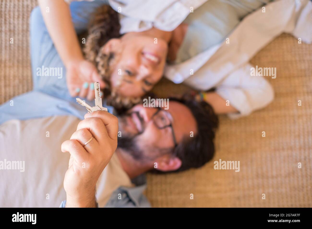 Happy young couple show new own house keys excited to move together, smiling loving adult husband and wife overjoyed first time buyers relocate rent shared apartment Stock Photo