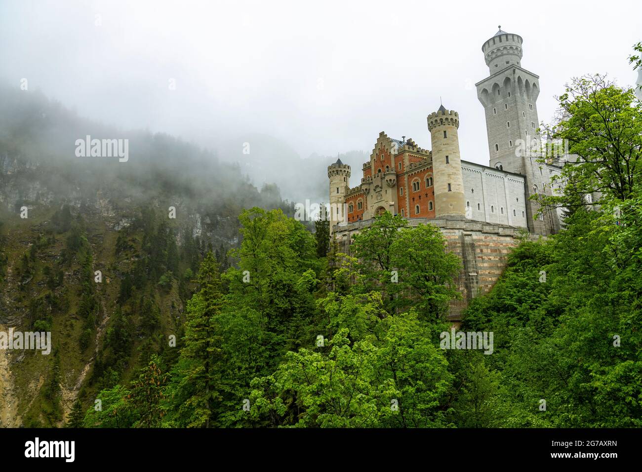 View of Neuschwanstein Castle with clouds and green forests, Schwangau, Upper Bavaria, Germany Stock Photo