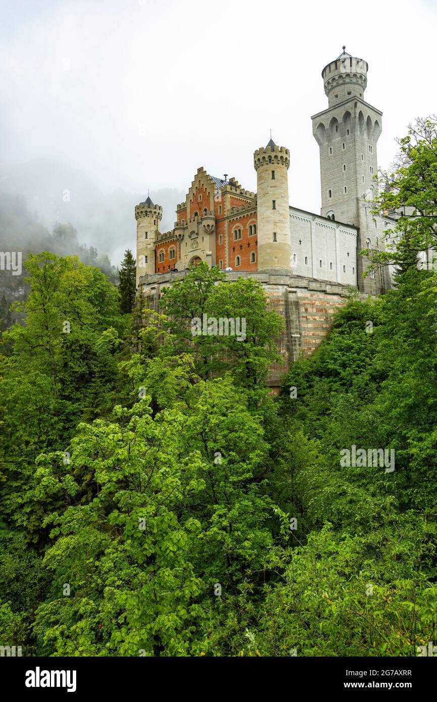 View of Neuschwanstein Castle with clouds and green forests, Schwangau, Upper Bavaria, Germany Stock Photo