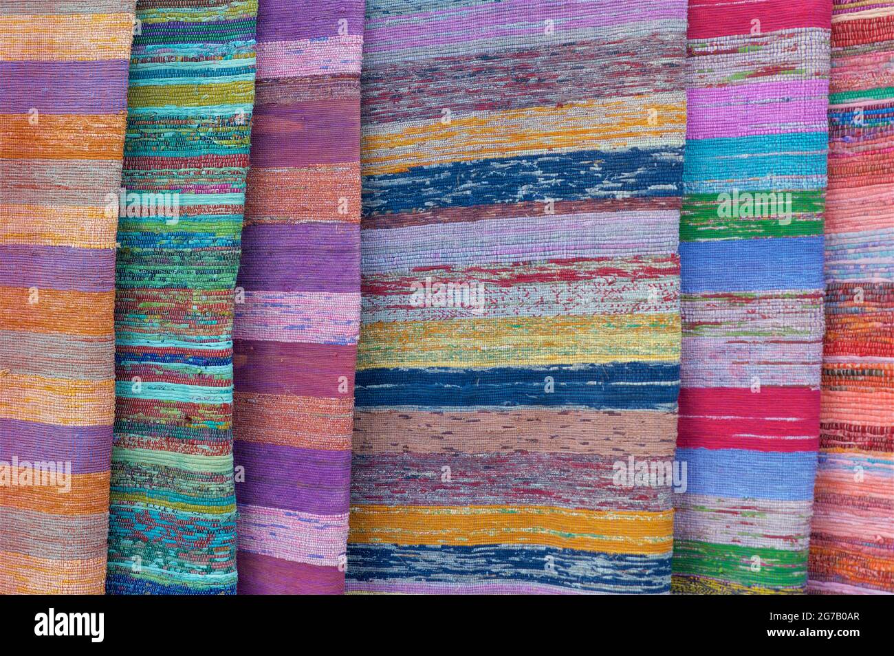 Rugs made from recycled fabric for sale on a market stall at a Womad