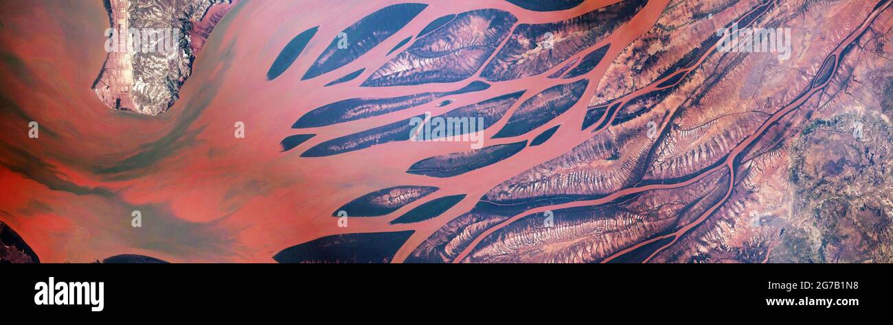 Betsiboka River Delta, Madagascar The Betsiboka River Delta empties into the Mozambique Channel at Bombetoka Bay in northwest Madagascar. The red and orange colored waters of the river are due to sediment eroding from surrounding floodplains. High erosion rates of silt here are attributed to a century of deforestation of rainforests and coastal mangroves. Surrounding this river delta are coffee plantations, one of Madagascar's many export crops. From International Space Station ISS156  An optimised and digitally enhanced version of an NASA image / credit NASA Stock Photo