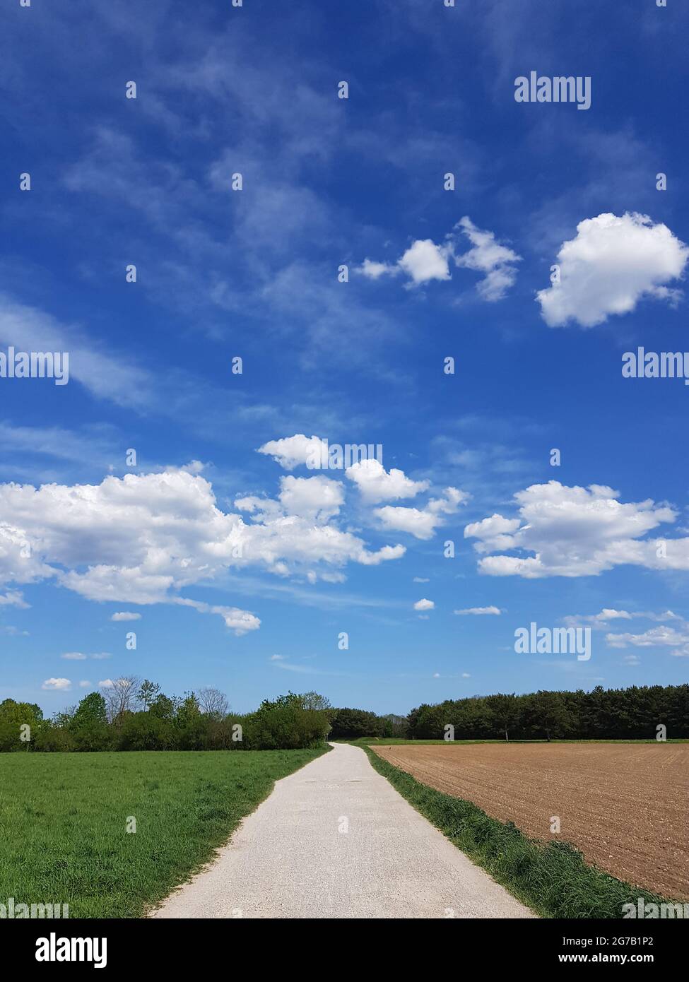 Blue sky with clouds and dirt road Stock Photo - Alamy