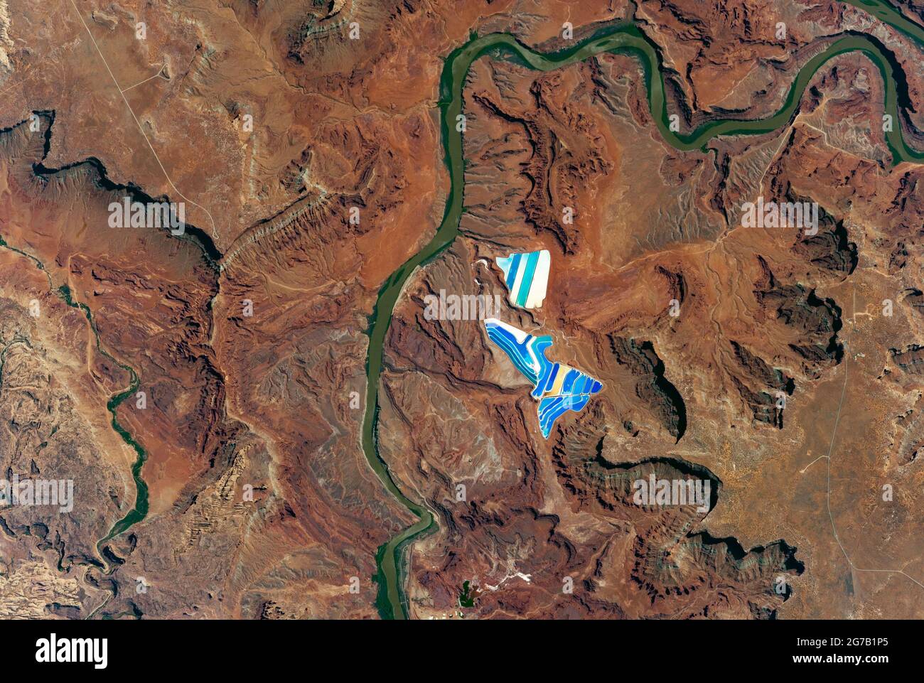 Solar evaporation ponds outside the city of Moab, Utah, USA, looking like broken blue and white porcelain in the soil. Photographed from the International Space Station (ISS). There are 23 colourful ponds spread across 400 acres, part of a large operation toÊmine potassium chloride, high in demand as fertilizer. The Colorado Plateau. 26 June 2017.  An optimised and digitally enhanced version of an NASA image / credit NASA Stock Photo
