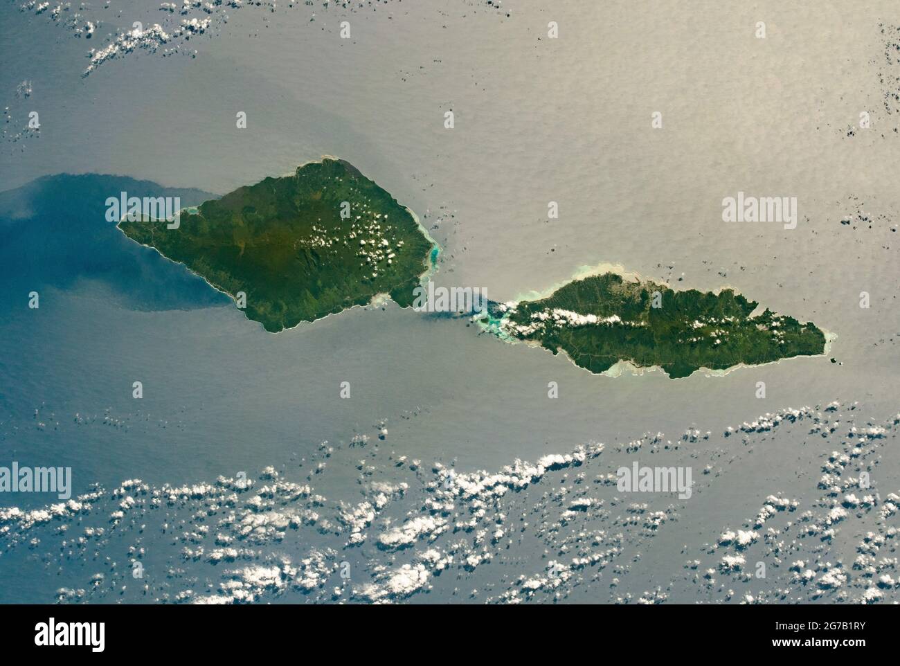 Savai'i and Upolu, Samoa, photographed from the International Space Station as it passed over the South Pacific Ocean. Savai'i, the westernmost Samoan Island, is 80 km (50 mi) long; Upolu is nearly as long (74 km/46 mi). The dark green centres of the islands reflect the denser tropical forests and higher elevations in comparison to the lower, light-green coastal regions around the edges. Apolima Strait separates the 2 islands. A unique, optimised and digitally enhanced version of an NASA image / credit NASA Stock Photo
