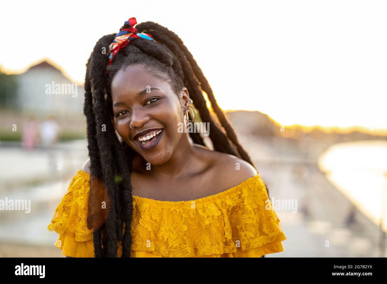 Happy young woman with dreadlocks outdoors Stock Photo
