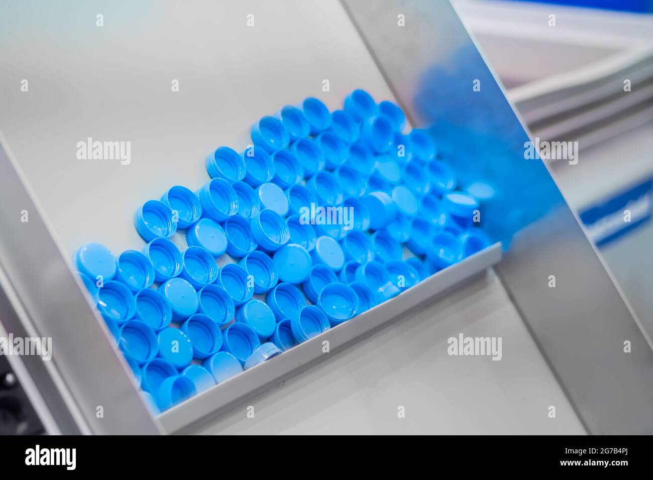 Many blue plastic bottle caps moving on conveyor belt production line Stock Photo Alamy