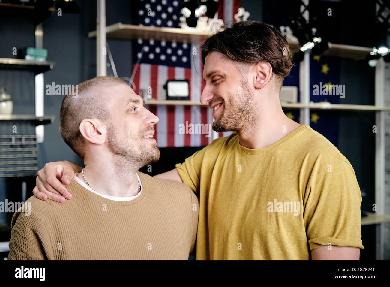 Two young affectionate gay men embracing and looking at each other Stock Photo