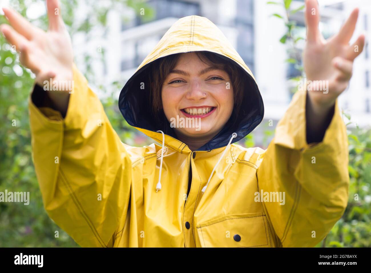 Happy young woman with yellow rain jacket with hood, Baden-Wuerttemberg, Germany Stock Photo