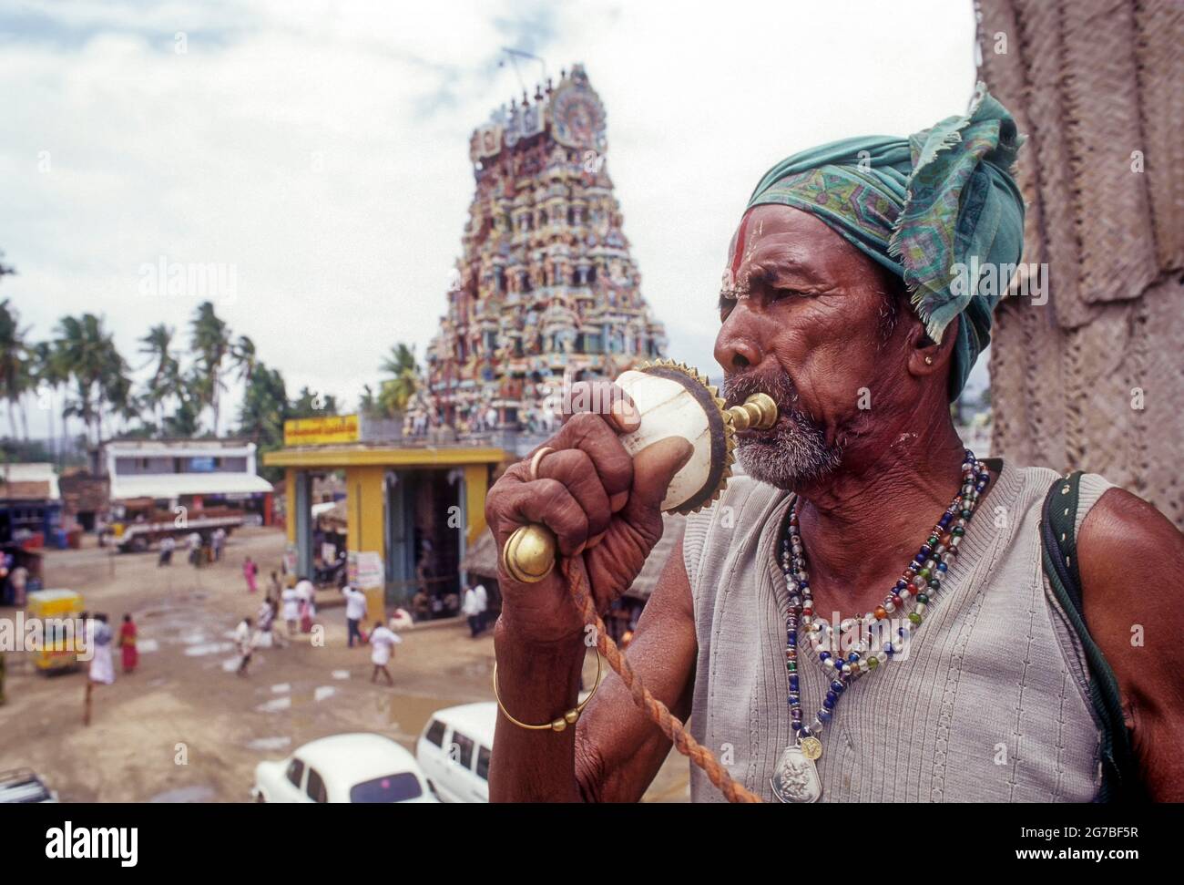 A Sadhu blowing a conch shell in front of Patteeswarar Swamy Temple at Perur in Coimbatore, Tamil Nadu, India Stock Photo